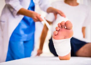 47971637 - injury leg. young man with injured leg. young woman doctor helps the patient